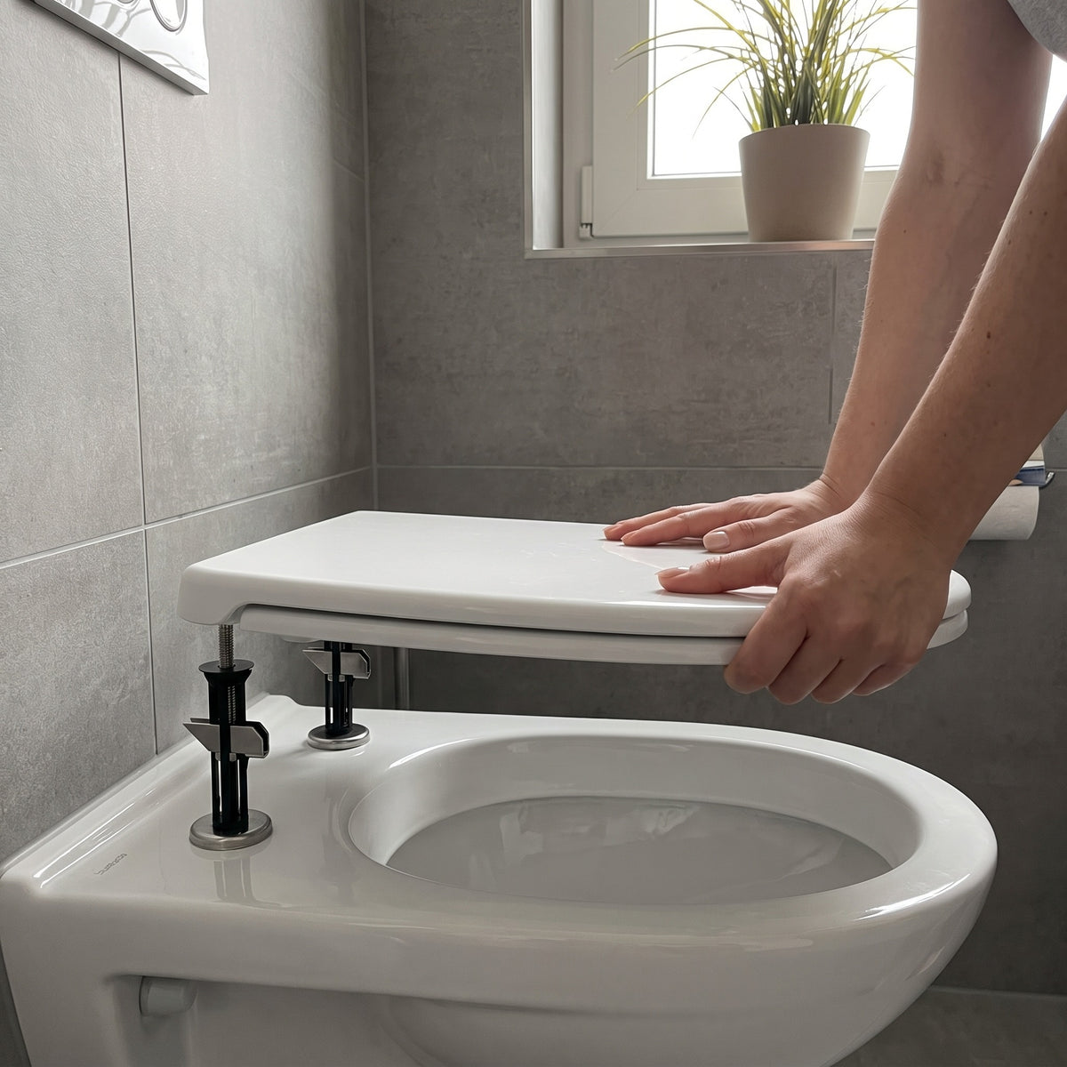 WC-Sitz wird aufgesetzt